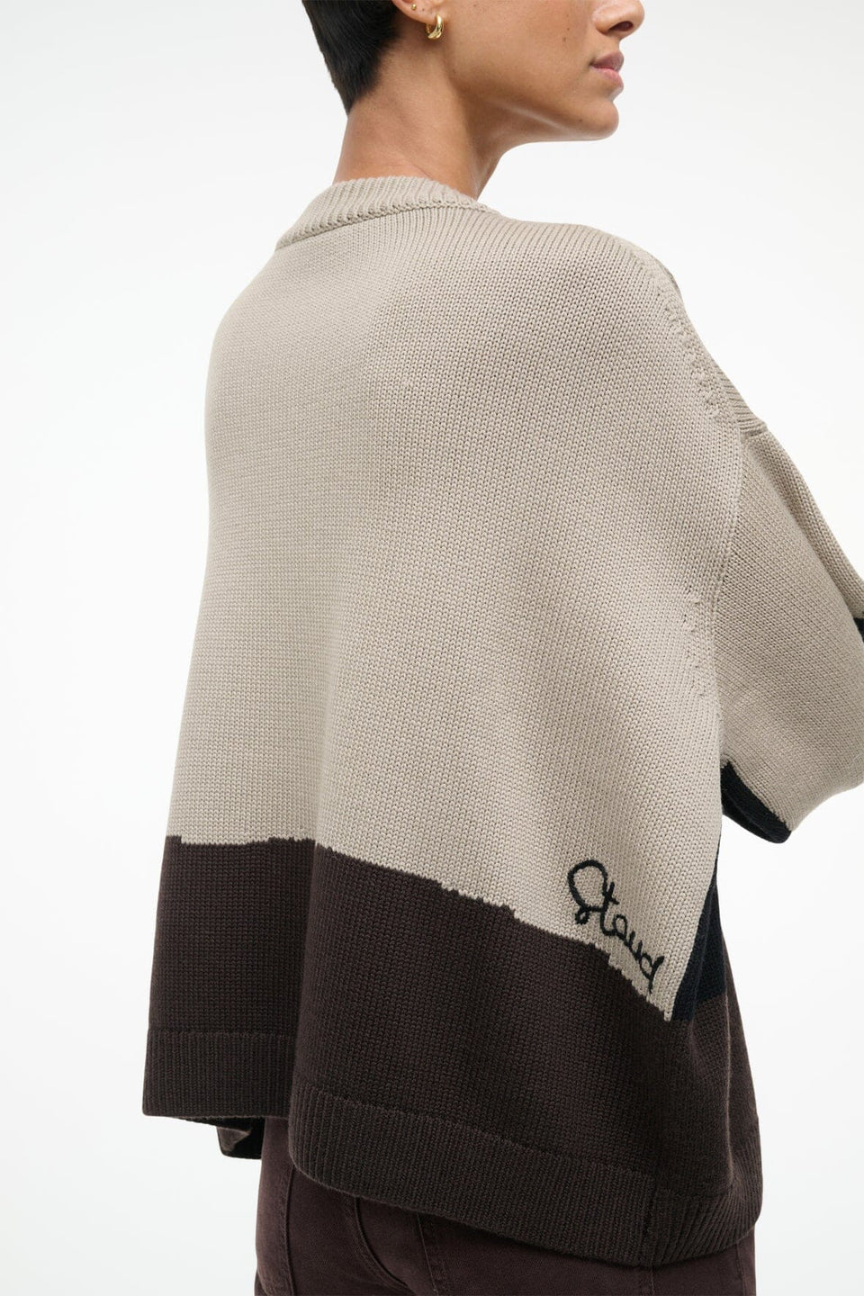 Beige and brown color-blocked sweater with 'Staud' branding on a white background