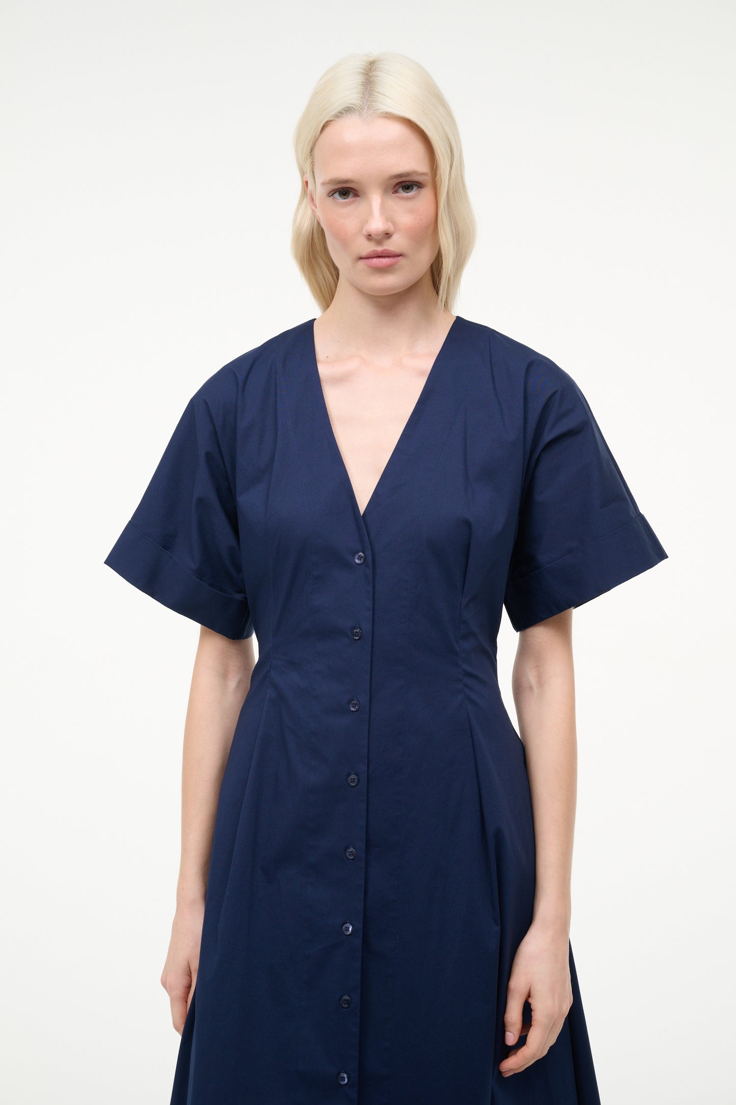 Woman wearing a navy blue dress against a white background