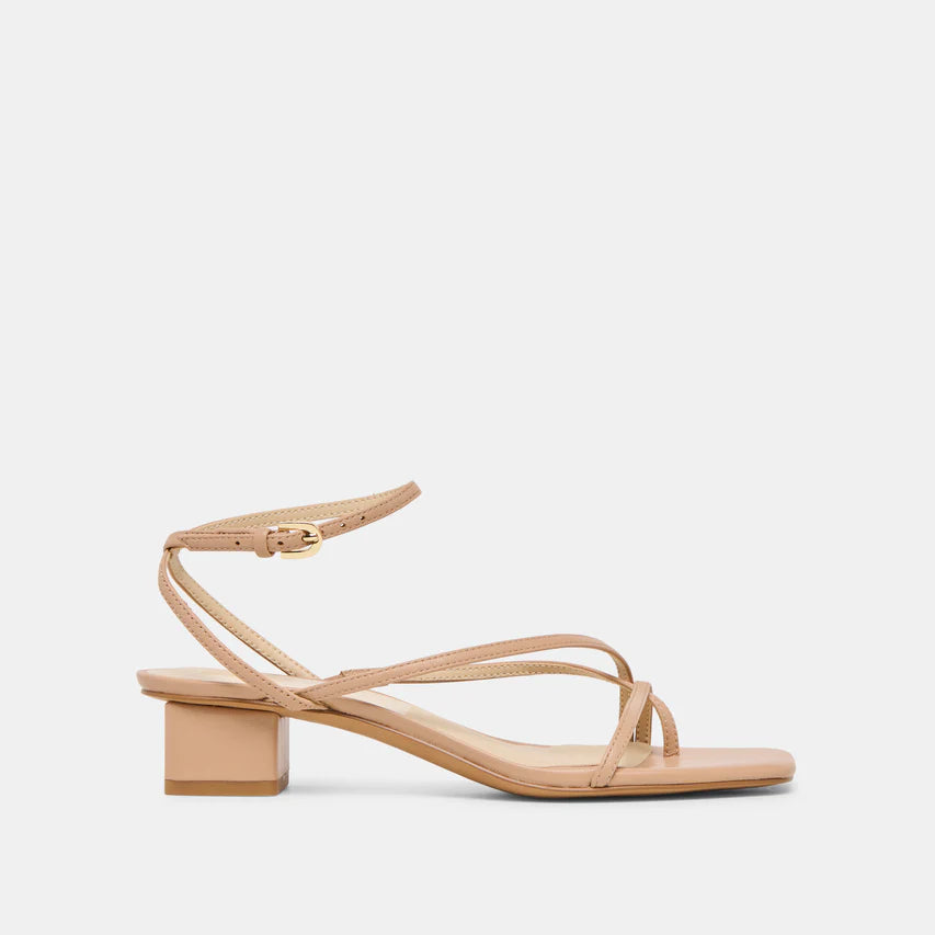 Tan strappy sandal with a block heel and buckle closure on a light beige background
