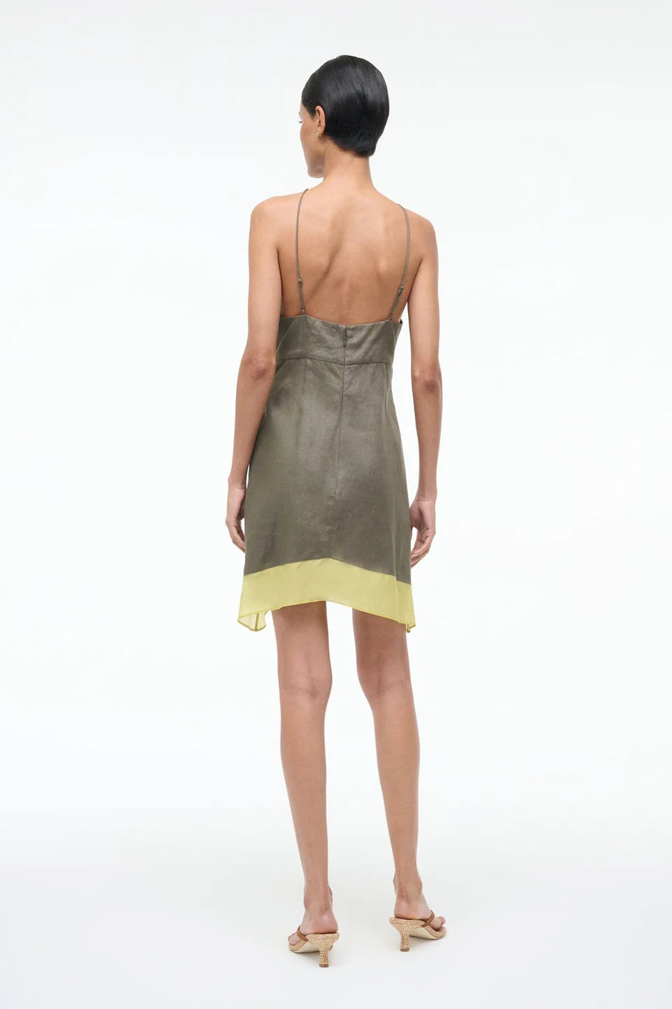 Woman wearing a green and yellow dress on a white background