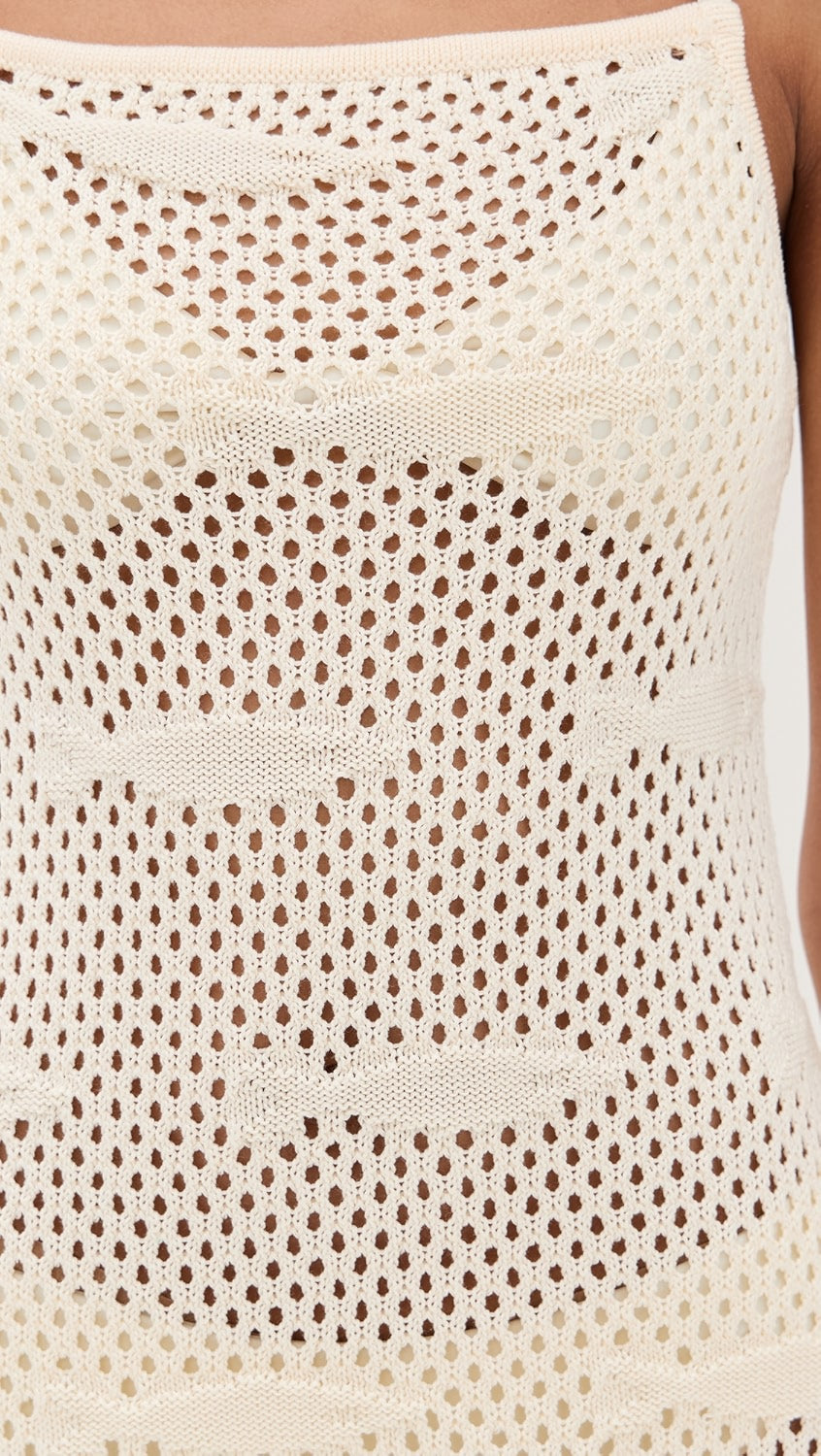 Close-up of a beige crochet top with a textured pattern.
