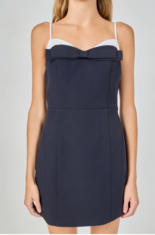 Navy blue dress with white top on a plain background