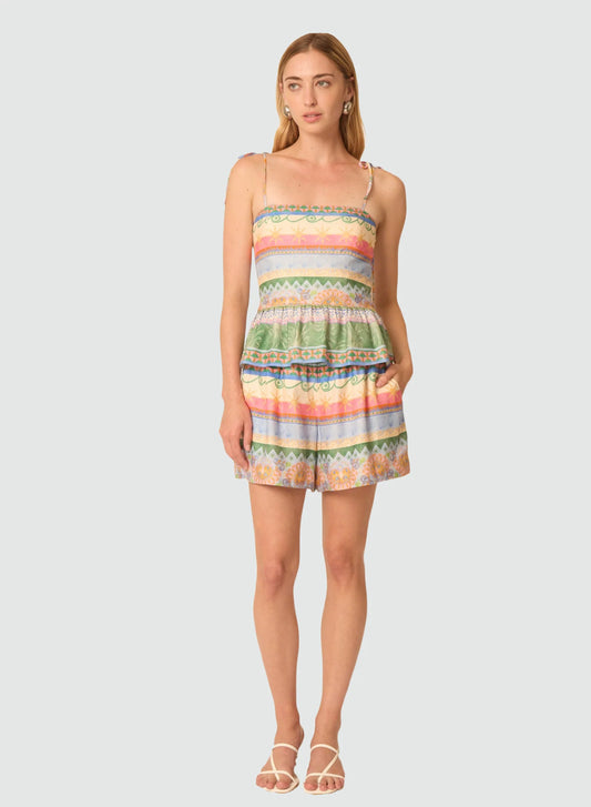 Woman wearing a colorful striped dress on a light gray background