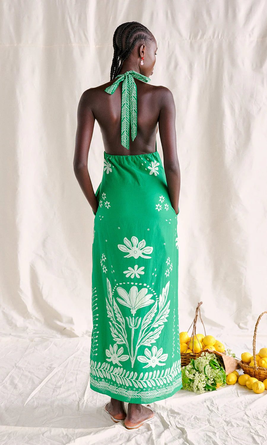Woman wearing a green floral dress with a white background