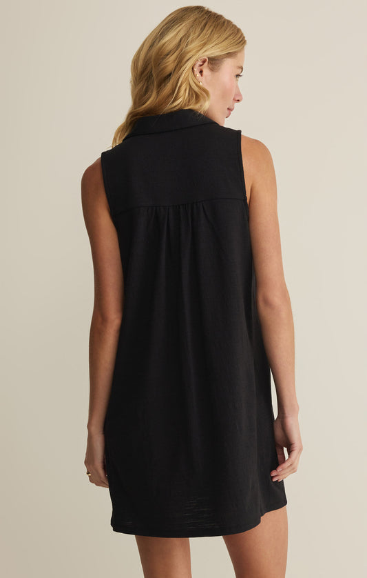 Woman wearing a black sleeveless dress against a beige background