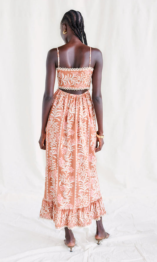 Woman wearing a coral sleeveless midi dress against a white background