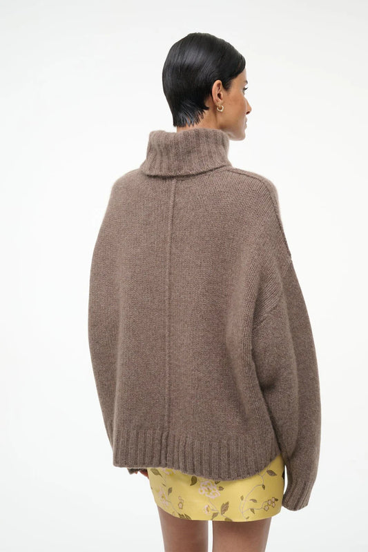 Person wearing a brown sweater on a white background