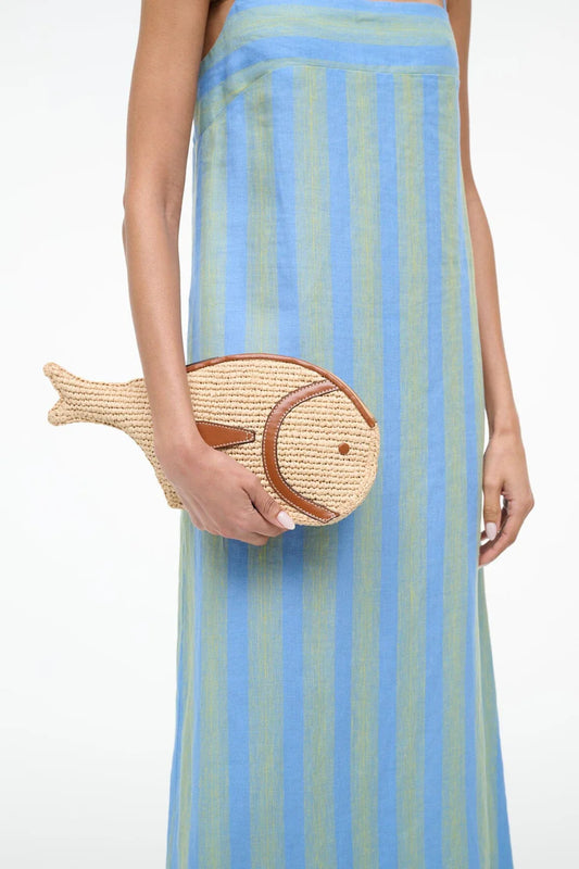 Person wearing a blue and green striped dress holding a fish-shaped clutch.