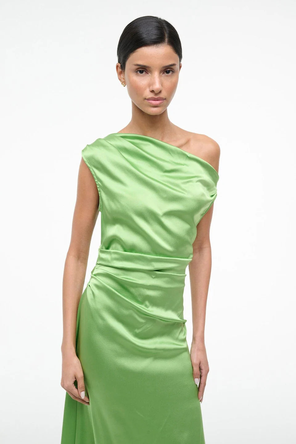 Woman wearing a green one-shoulder dress on a white background