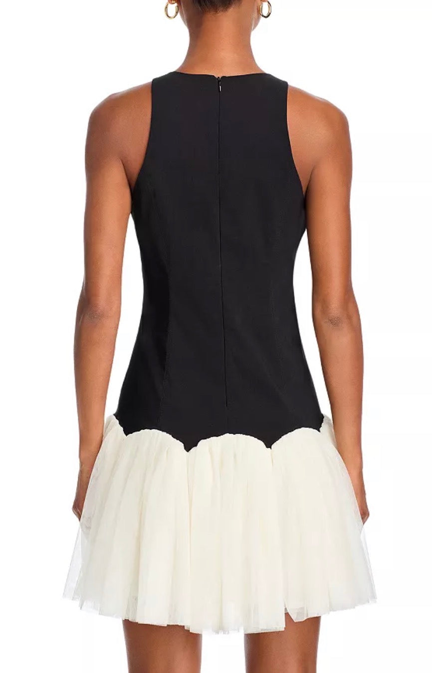 Black dress with a white skirt worn by a model on a white background