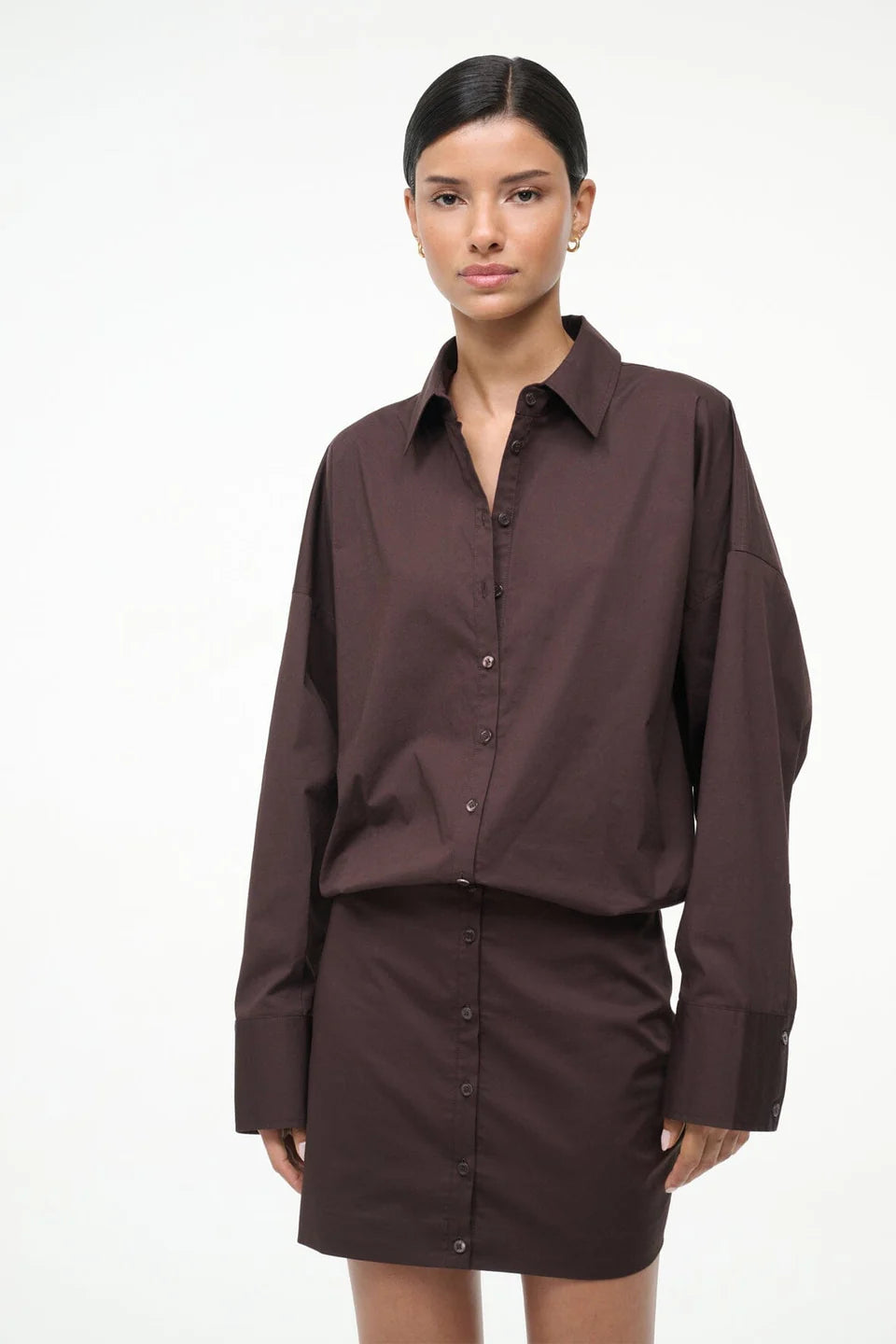 Woman wearing a brown shirt and skirt set on a white background