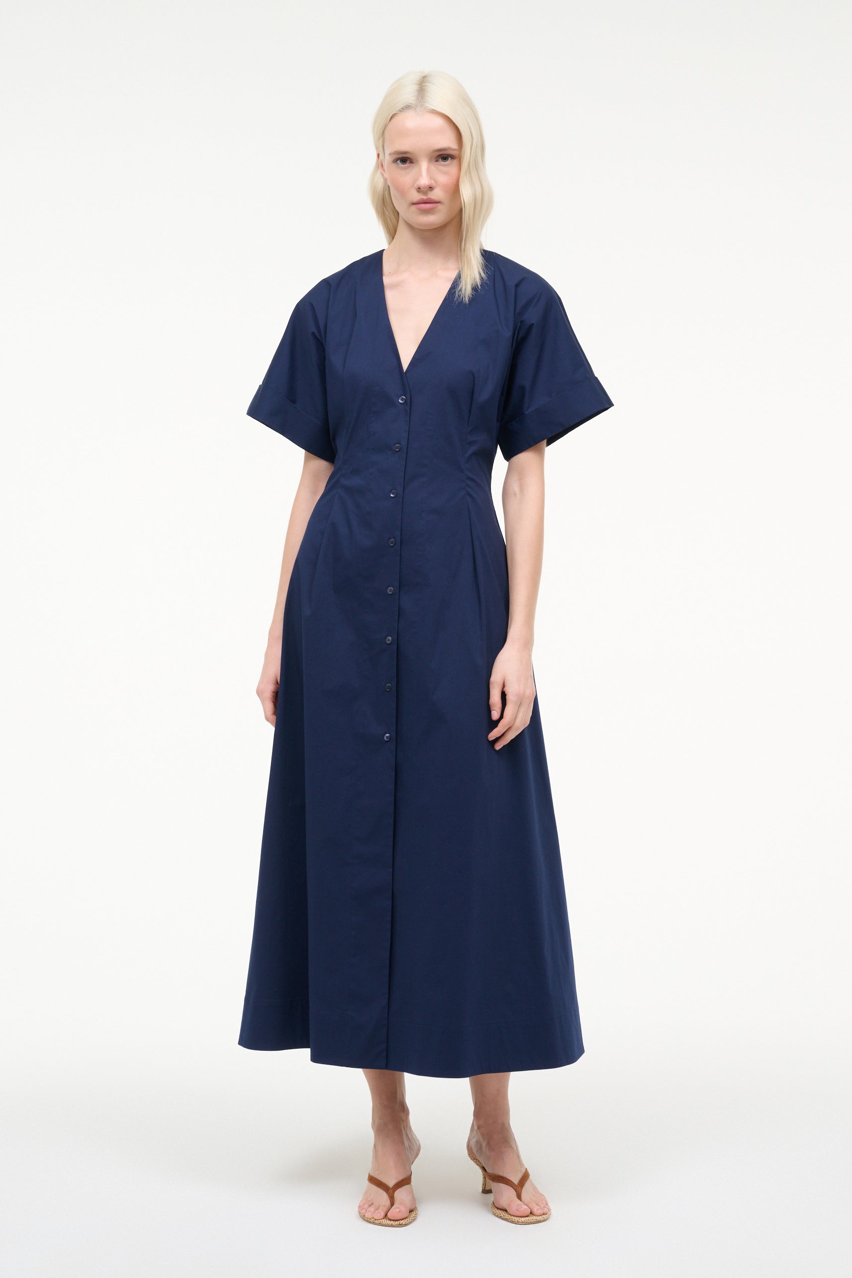 Woman wearing a navy blue dress on a white background