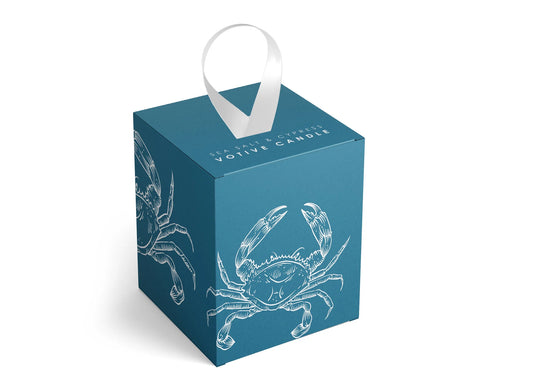 Blue votive candle box with white crab illustrations and a white ribbon on a white background