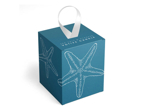 Blue votive candle box with starfish design and white handle on a white background. Scent of sea salt and cypress.