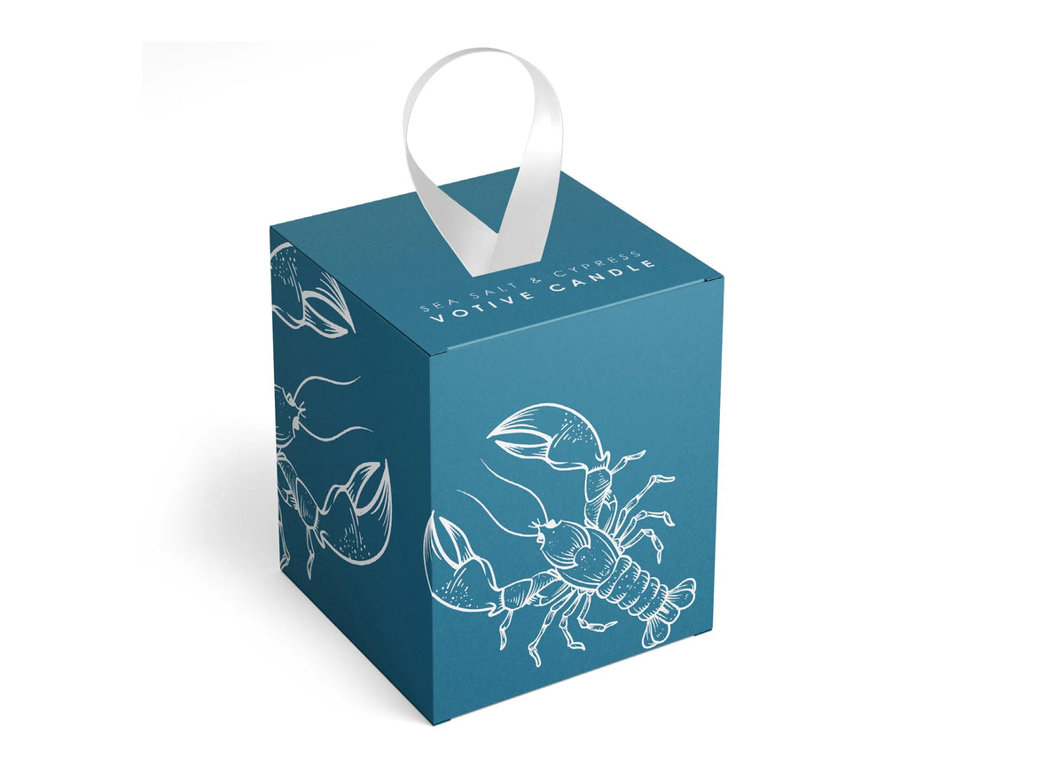 Blue votive candle box with white lobster illustrations and a white handle on a white background. 
