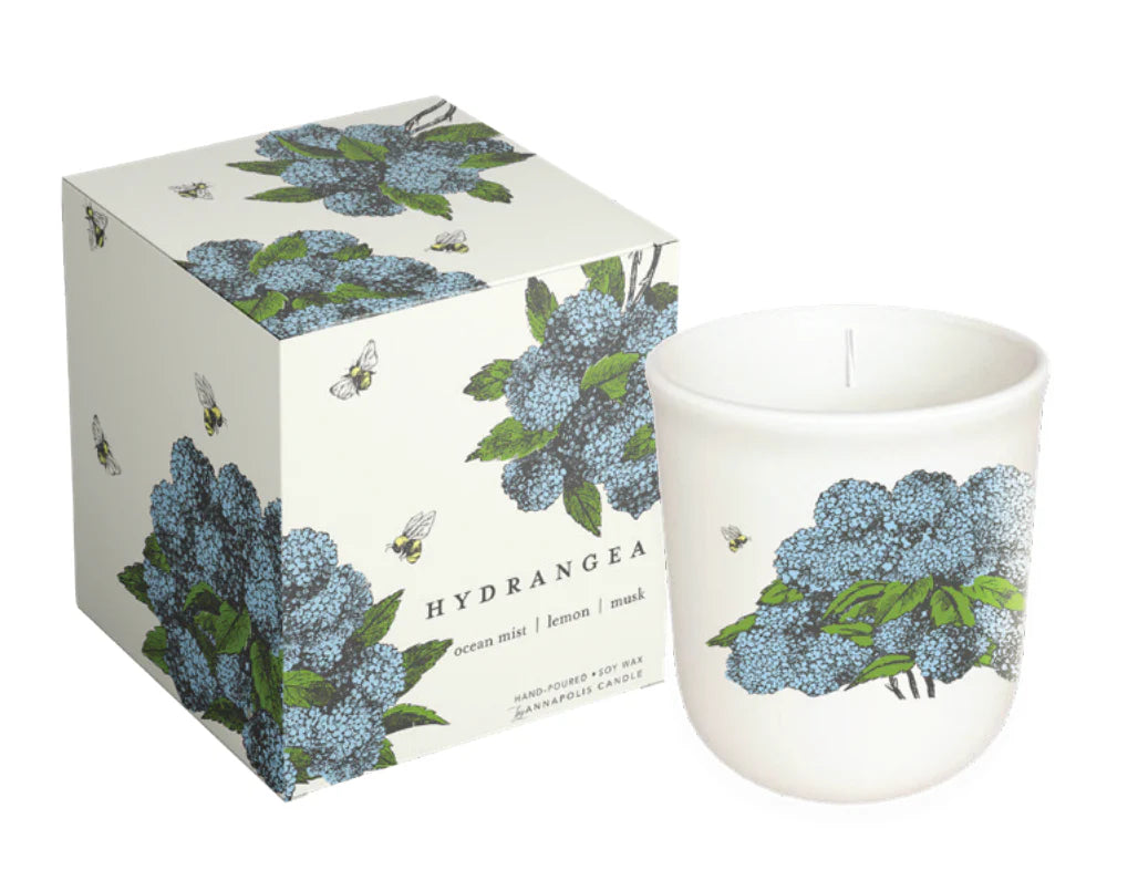 Candle with hydrangea design and matching packaging on a white background. Scents of ocean mist, lemon, and musk. Hand Poured soy wax candle.