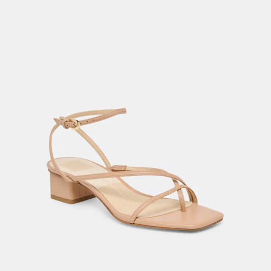 Dolce Vita light tan strappy leather sandal with a block heel on a light gray background