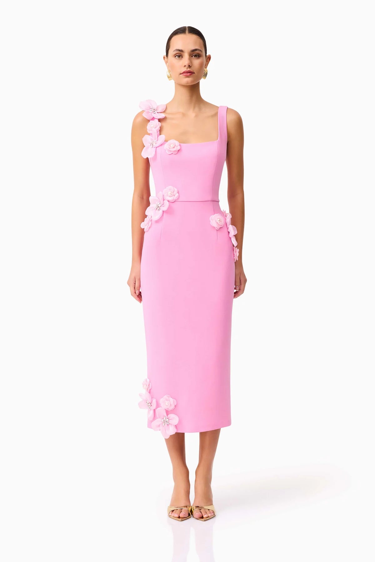 Woman wearing a pink square neck midi dress with 3D floral details on a white background