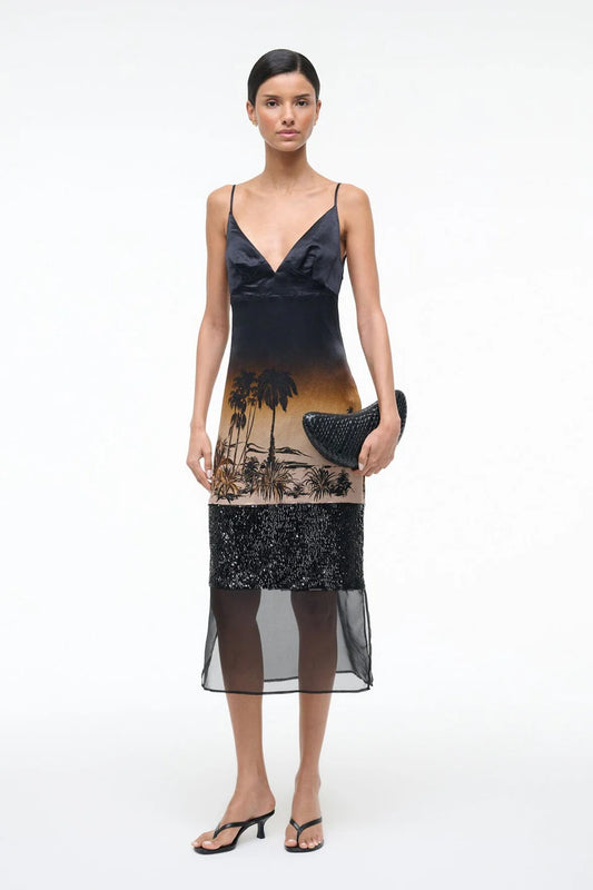 Woman wearing a black dress with a palm tree design on a white background