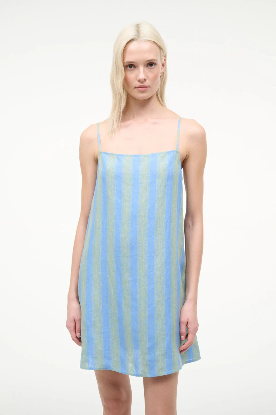 Woman wearing a light blue and green striped dress on a white background