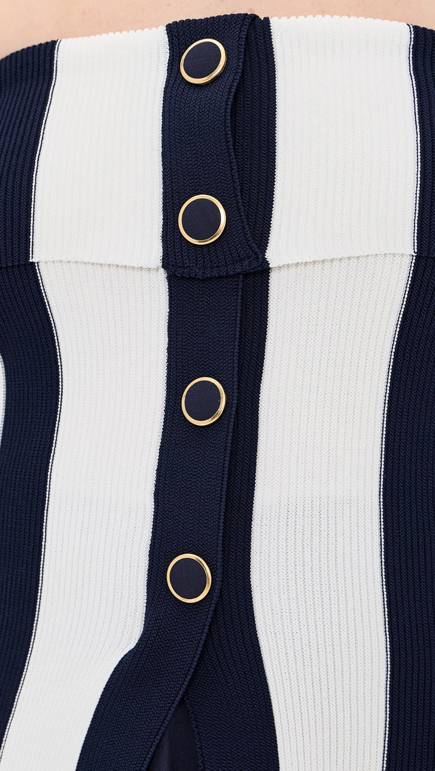Close-up of a navy and white striped garment with gold buttons.
