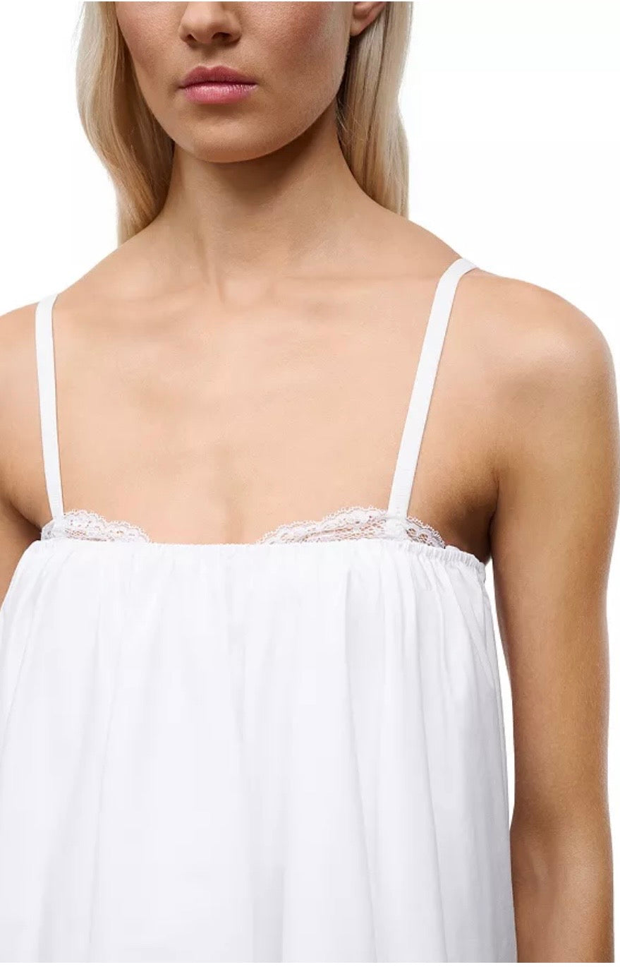 White lace-trimmed top worn by a model on a white background