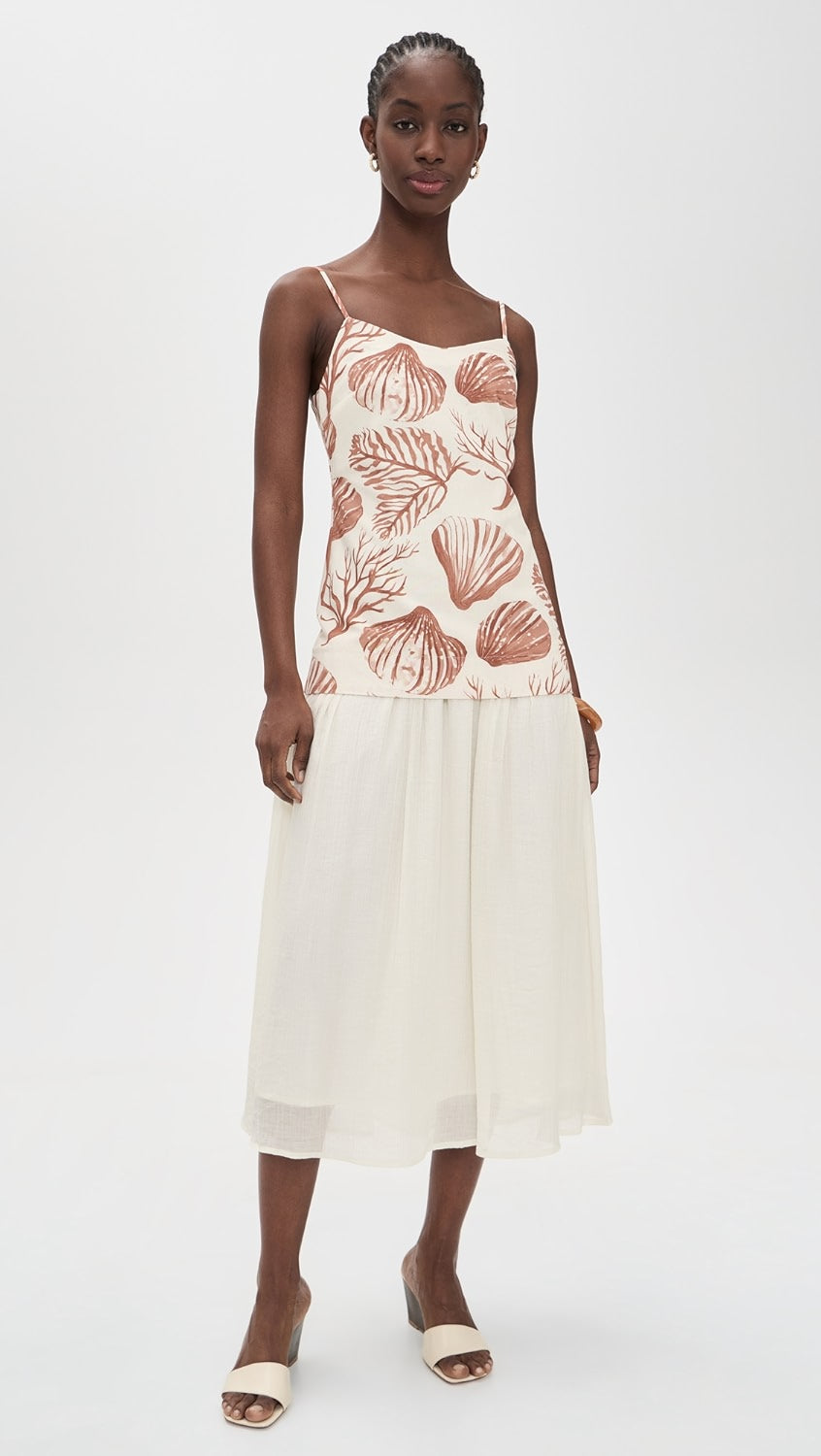 Woman wearing a dress with shell pattern on a white background