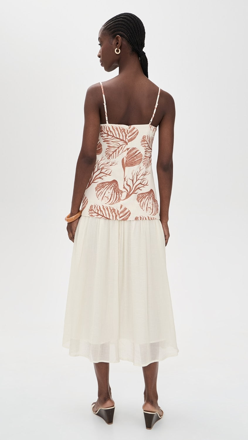 Woman wearing a white dress with floral patterns on a white background