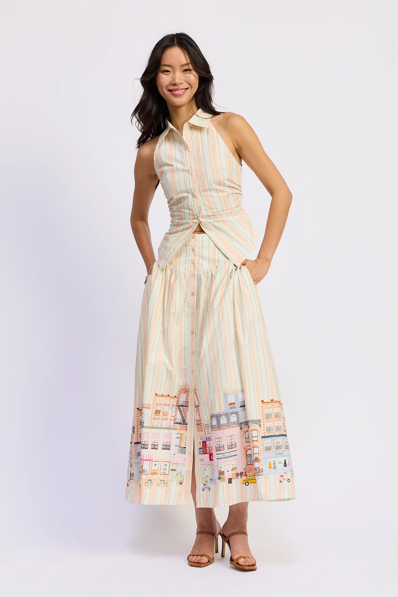 Woman wearing a sleeveless dress with a patterned design on a white background