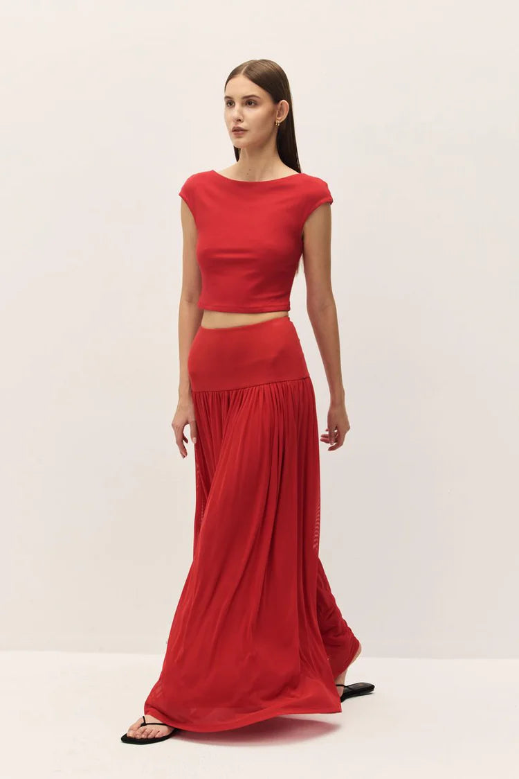Woman wearing a red two-piece outfit on a white background