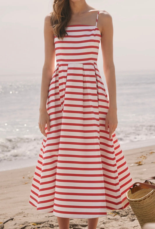 Woman wearing a red and white striped dress on a beach.