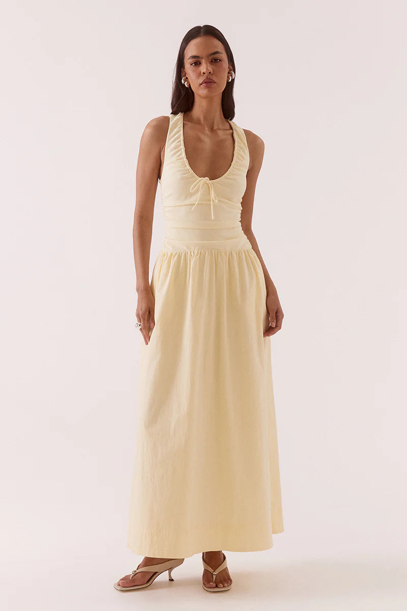 Woman wearing a light yellow sleeveless dress on a white background