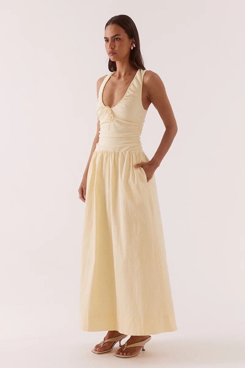 Woman wearing a light yellow dress against a white background