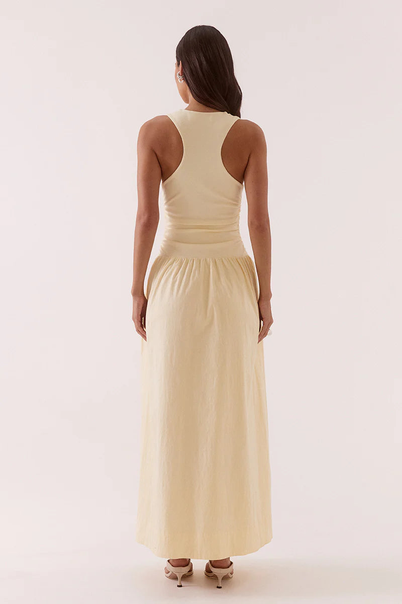 Woman wearing a light yellow sleeveless dress on a white background