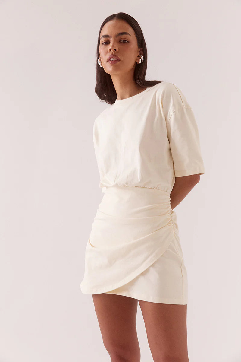Woman wearing a white dress against a plain background