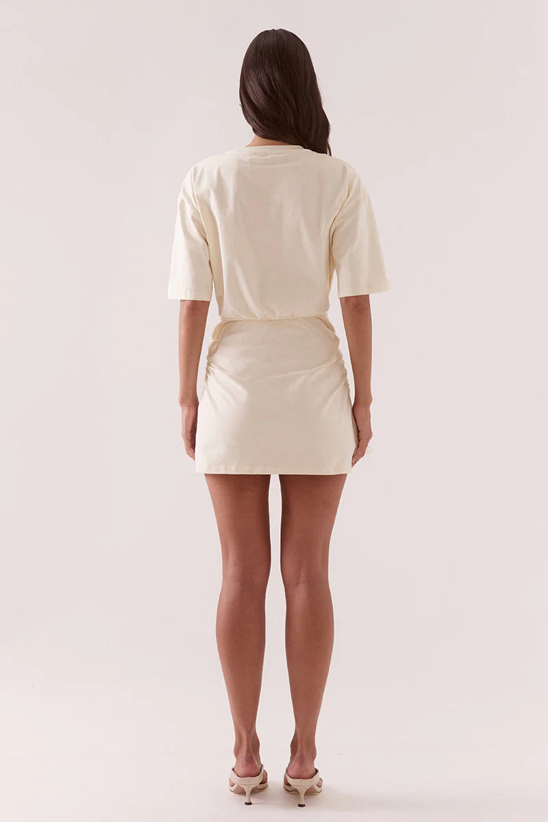 Woman wearing a cream-colored dress on a white background