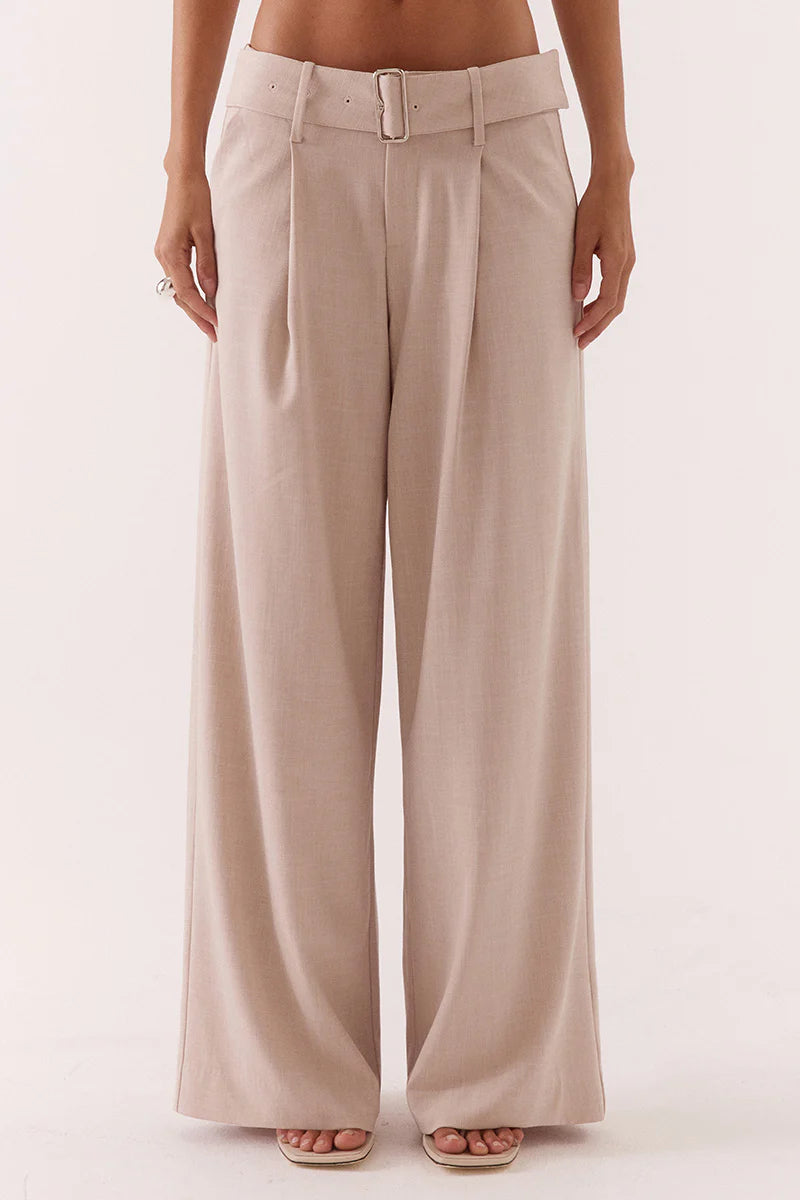 Beige wide-leg pants worn by a person on a white background