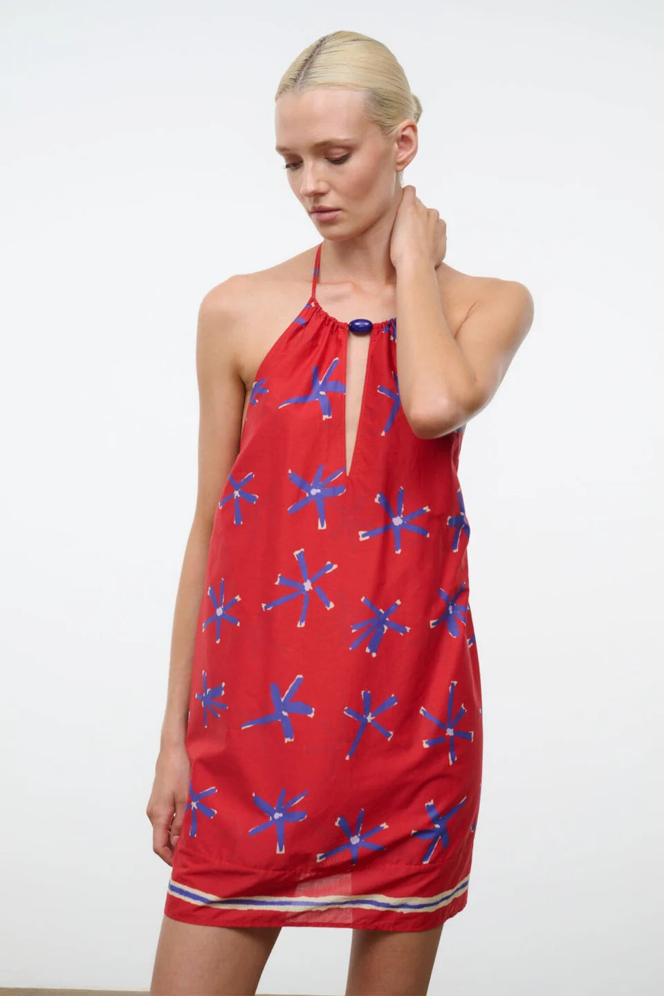 Woman wearing a red dress with blue star patterns on a white background