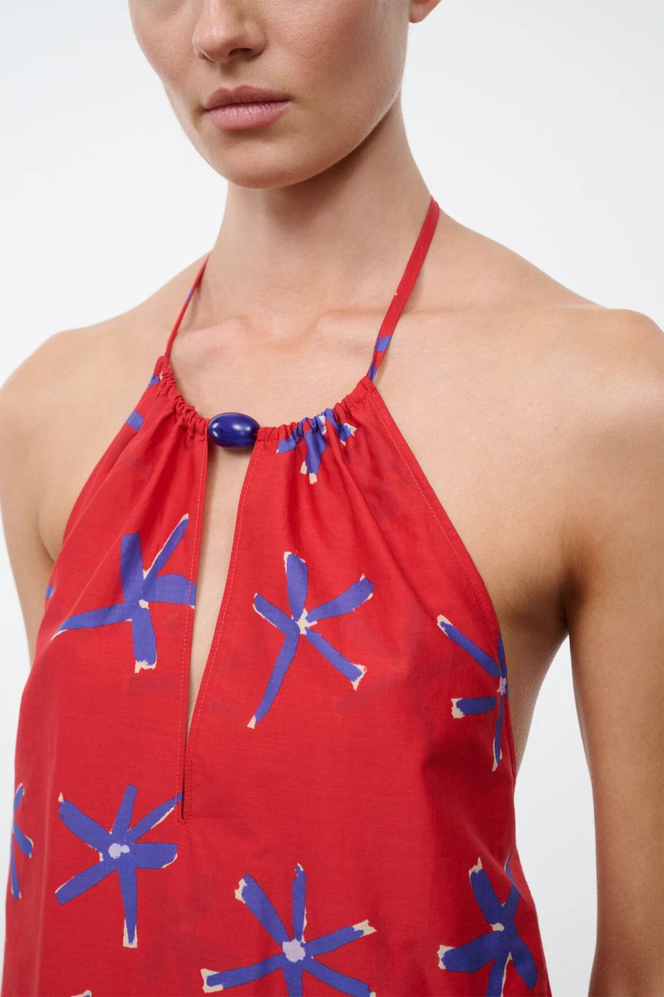 Red halter top with blue floral patterns on a plain background