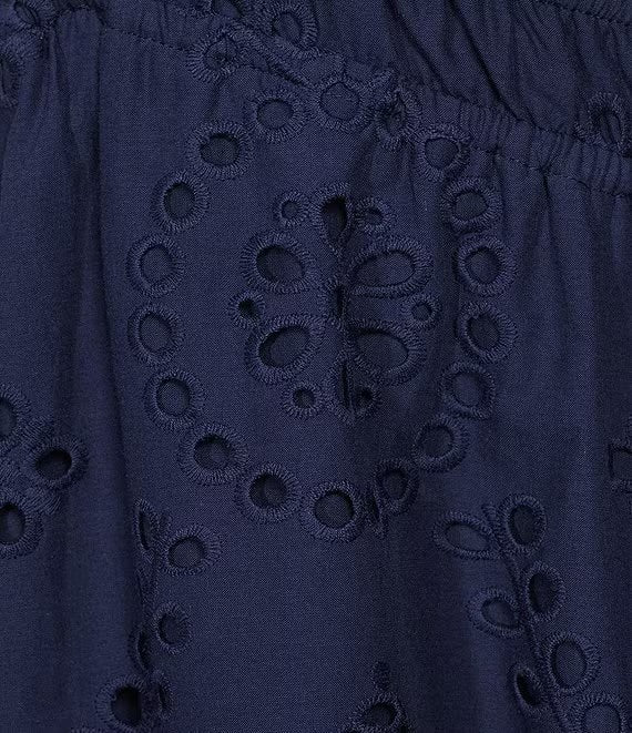 Close-up of a navy blue fabric with eyelet embroidery and an elastic waistband.