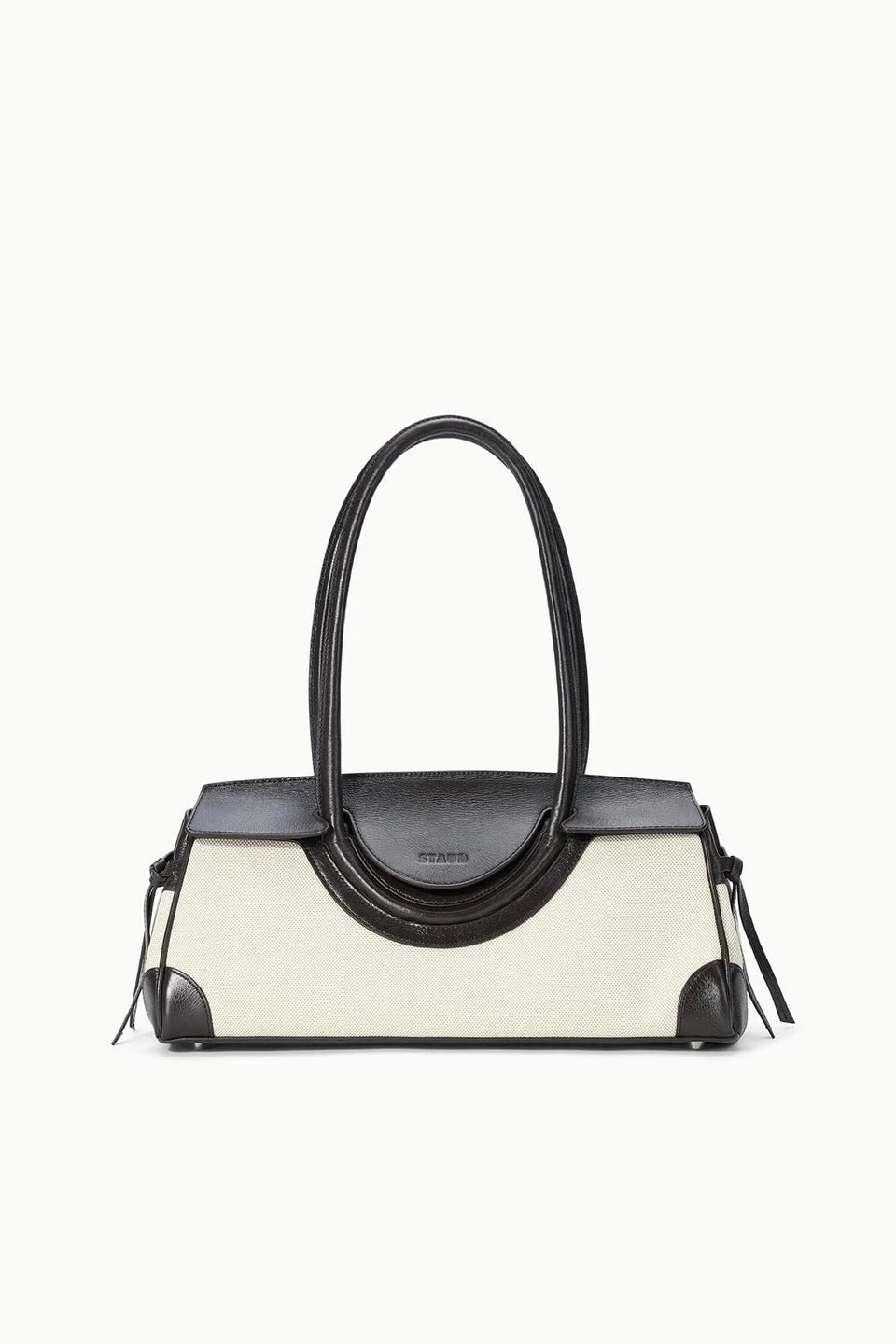 Handbag with black top handle and cream body on a white background