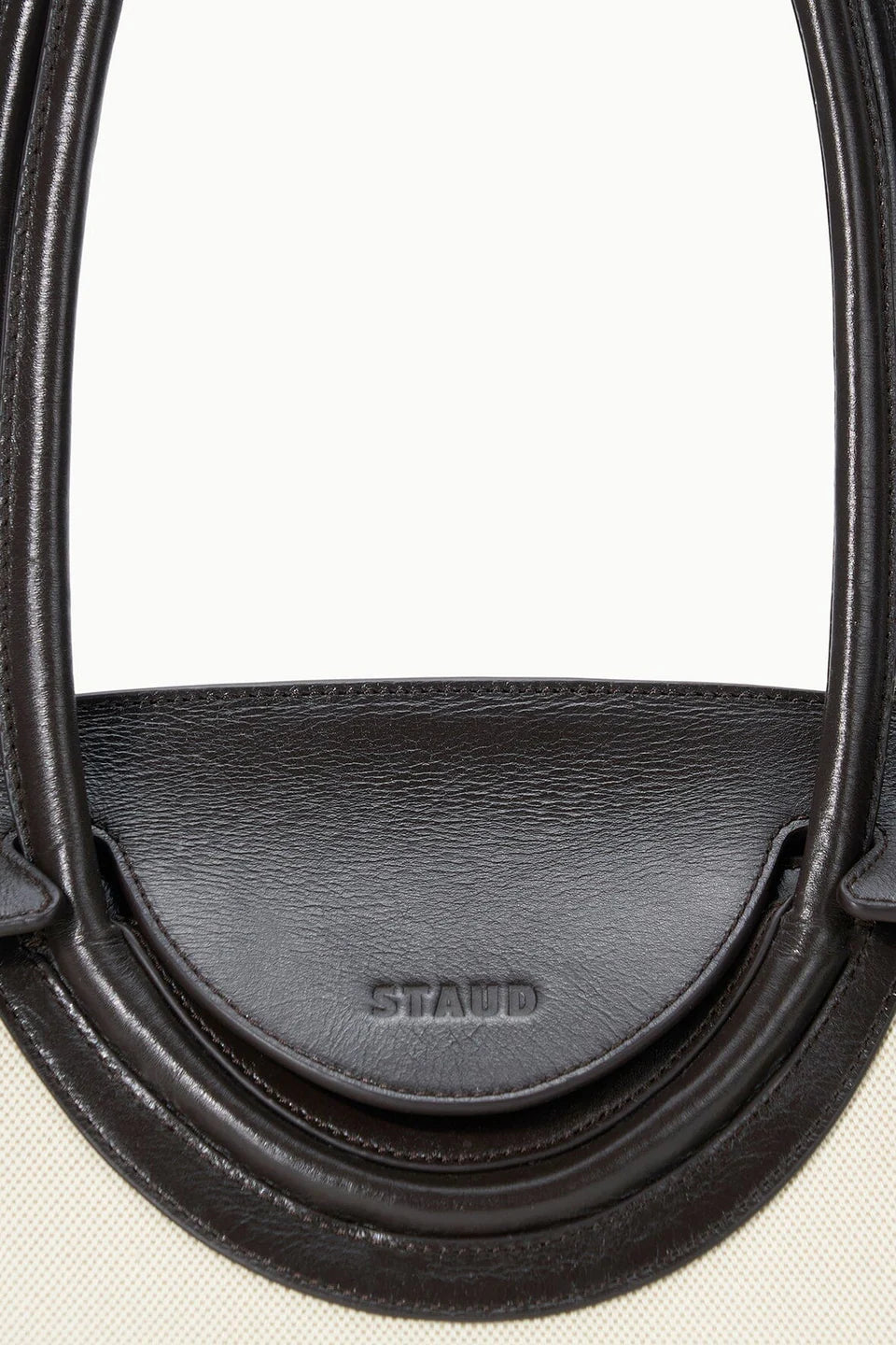 Close-up of a black leather saddle pad with 'STAND' branding on a white background