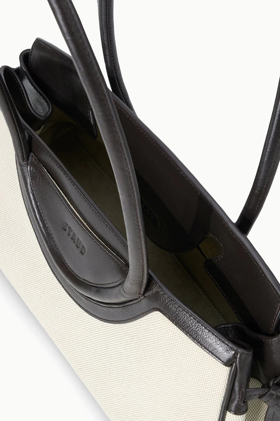Close-up of a black handbag with visible brand name on a white background