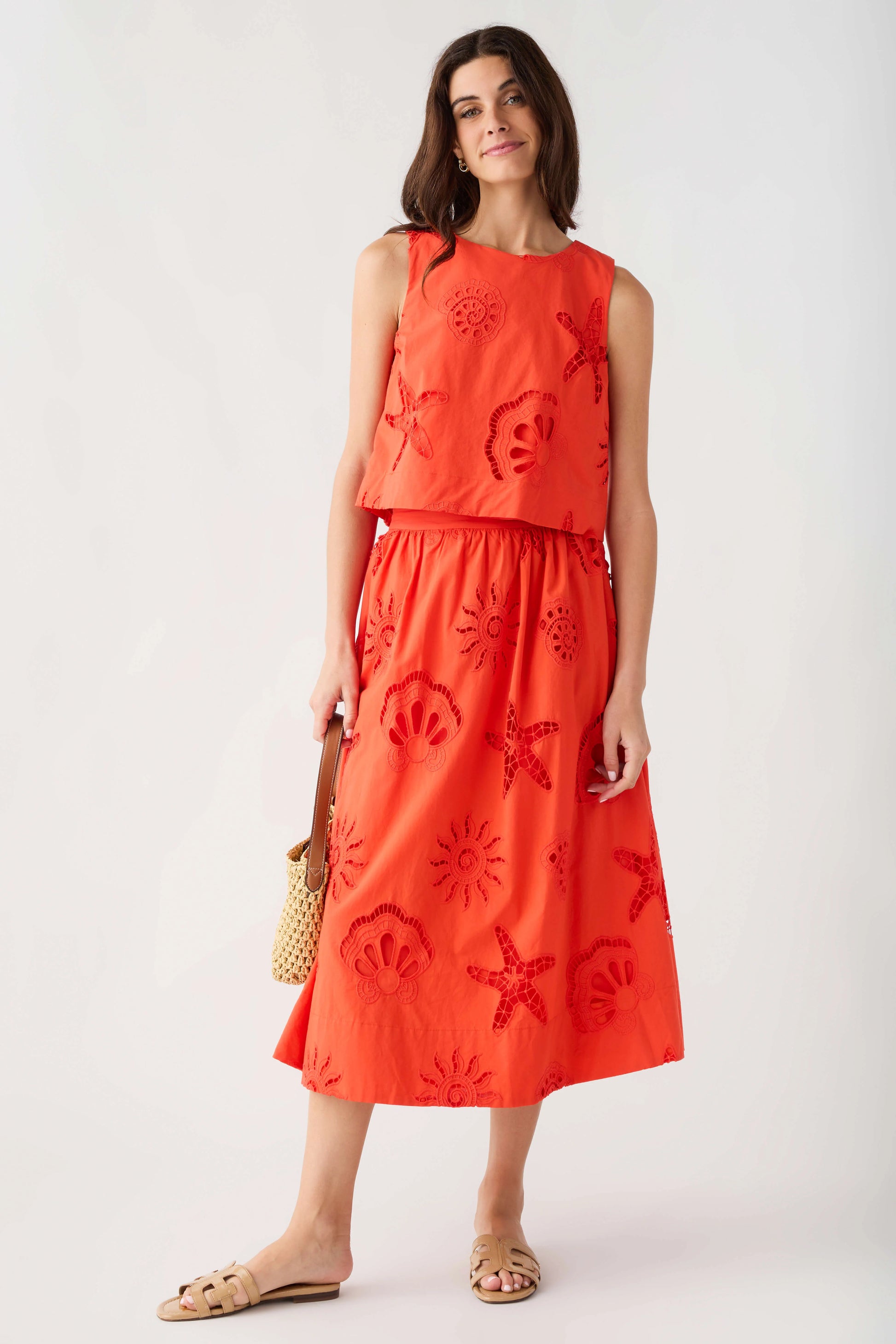 Woman wearing a red dress with floral patterns on a white background