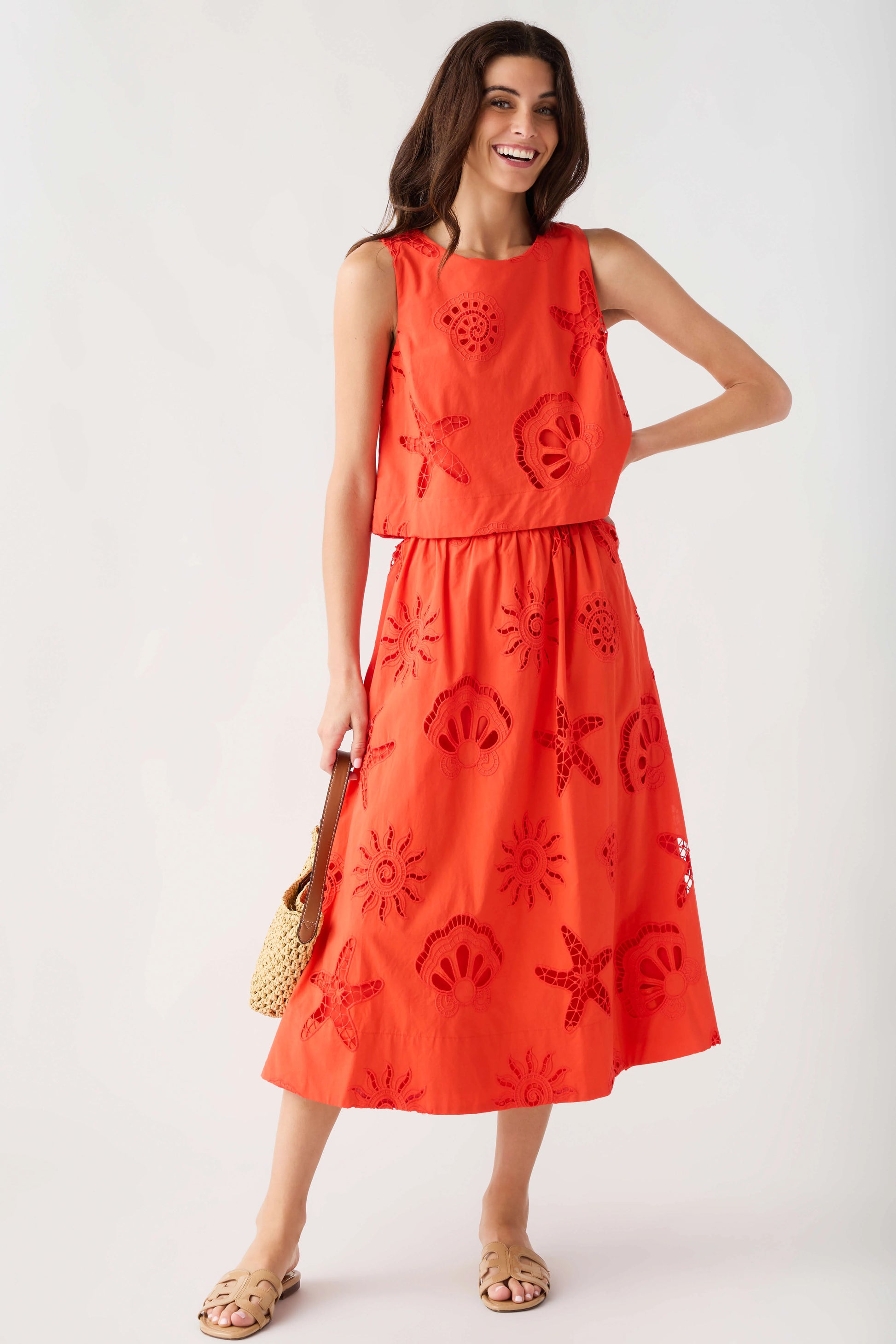 Woman wearing a red dress with floral patterns on a white background