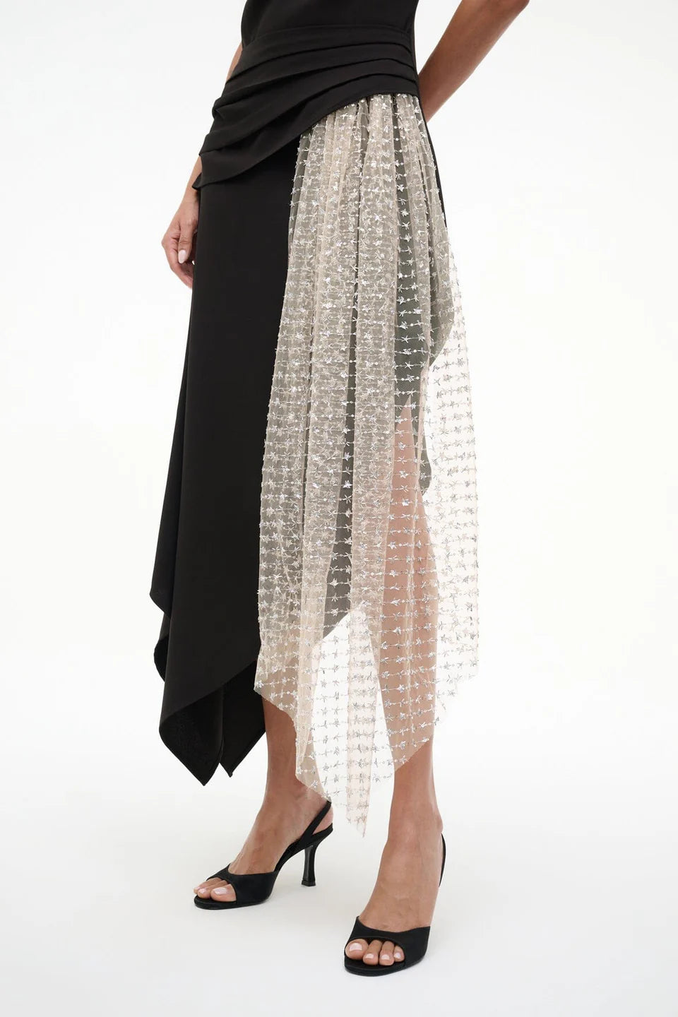 Black and silver beaded skirt worn by a person on a white background