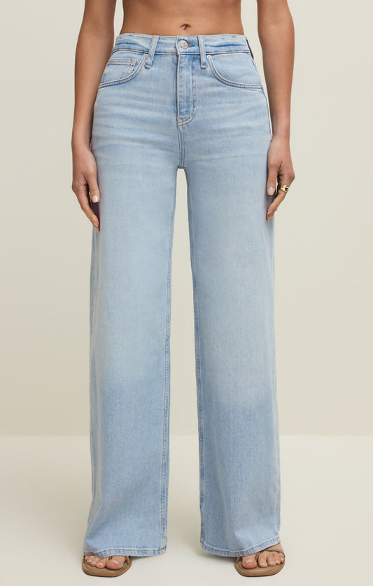 Light blue jeans worn by a person on a plain background