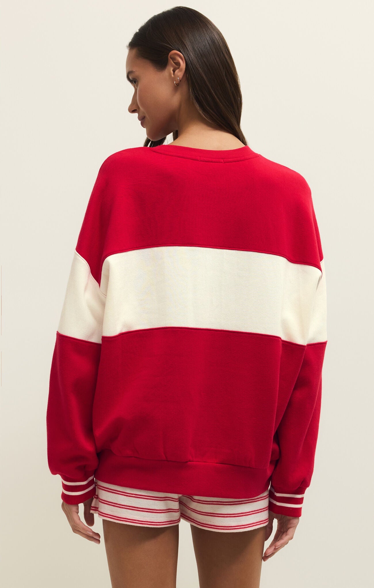Person wearing a red and white striped sweater on a plain background