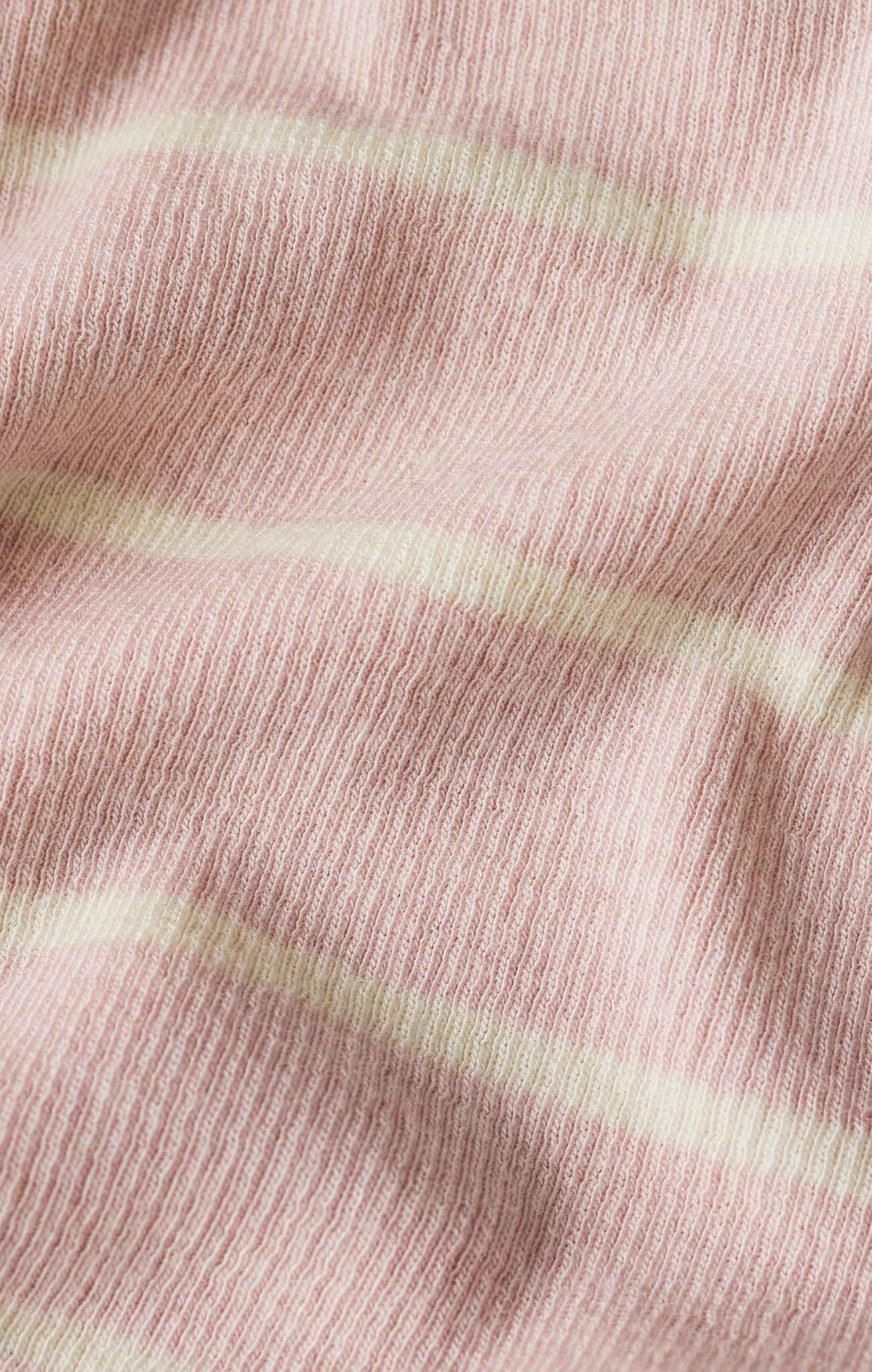 Close-up of pink fabric with subtle texture and light green stripes.