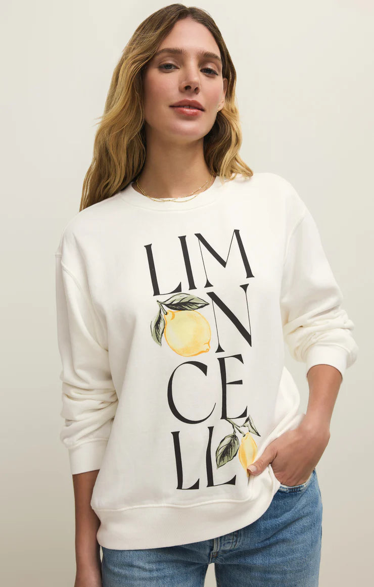 Woman wearing a white sweatshirt with lemon design and text